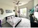 Bright bedroom featuring a floral bedspread, a ceiling fan, and decorative butterflies, offering comfort and style at 4223 Sunset Preserve Blvd, Orlando, FL 32820