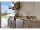 Outdoor kitchen with stainless steel grill, granite countertops, and sink, perfect for outdoor entertaining at 4223 Sunset Preserve Blvd, Orlando, FL 32820