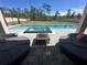 Inviting backyard featuring a pool, integrated spa, fire pit, and comfortable patio furniture on a paved deck at 4223 Sunset Preserve Blvd, Orlando, FL 32820