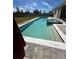Backyard pool with tanning ledge and spa features a white tile and paved patio at 4223 Sunset Preserve Blvd, Orlando, FL 32820