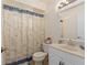 Nautical themed bathroom with a vanity, toilet, patterned shower curtain, and tile flooring at 5138 Andrea Blvd, Orlando, FL 32807