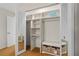 Walk-in closet with built-in shelves, bench seating, decorative baskets, and mirrored closet doors at 5138 Andrea Blvd, Orlando, FL 32807