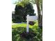 Charming mailbox with address plaque and flower-filled base amidst lush green lawn and mature trees at 5138 Andrea Blvd, Orlando, FL 32807