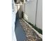Narrow side yard featuring a rock bed, greenery, and a well-maintained fence, enhancing privacy at 5138 Andrea Blvd, Orlando, FL 32807