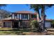 Charming two-story brick home with dark trim, a manicured lawn, and a large tree in the front yard at 9130 Dollanger Ct, Orlando, FL 32819