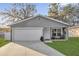 Charming single-Gathering home features a well-manicured lawn, attached garage, and a cozy front porch sitting area at 1208 Old Apopka Rd, Apopka, FL 32703