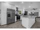 Modern kitchen features stainless steel appliances, a granite countertop island, and wood-look tile floors at 1208 Old Apopka Rd, Apopka, FL 32703