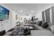 Open-concept living room with a large sectional sofa, wood-look tile floors, and a view of the kitchen at 1208 Old Apopka Rd, Apopka, FL 32703