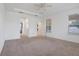 Spacious bedroom with neutral carpet, ceiling fan, and access to bathroom at 1918 Arden Oaks Dr, Ocoee, FL 34761