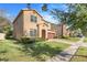 Two-story house with a tan exterior, brown garage door, and lush landscaping at 1918 Arden Oaks Dr, Ocoee, FL 34761