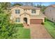 Two-story house with brown roof, brown garage door, and brick driveway at 1918 Arden Oaks Dr, Ocoee, FL 34761