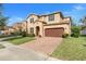 Tan two-story house with a brown garage door and a neatly landscaped lawn at 1918 Arden Oaks Dr, Ocoee, FL 34761