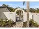 Elegant arched entrance with black metal gate and lush landscaping leading to the property at 2337 Worthington Rd, Maitland, FL 32751