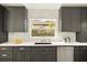 Well-lit kitchen featuring gray cabinets, stainless steel appliances, and a garden view at 2337 Worthington Rd, Maitland, FL 32751