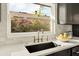 A close up of a kitchen sink with a gold faucet and garden view at 2337 Worthington Rd, Maitland, FL 32751