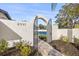 Arched gate entrance leading to the tennis court, showcasing well-maintained landscaping and attractive brick pathway at 2337 Worthington Rd, Maitland, FL 32751