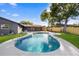 Backyard pool view, showcasing a lush lawn and sunlit atmosphere with a nice, dark grey home at 2631 Falmouth Rd, Maitland, FL 32751