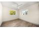 Bright bedroom with hardwood floors, a ceiling fan, and two windows overlooking the yard at 2631 Falmouth Rd, Maitland, FL 32751