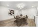 Bright dining room with view into the kitchen, modern light fixture, and wood floors at 2631 Falmouth Rd, Maitland, FL 32751