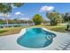 Inviting kidney-shaped pool with lake view, set in a lush green lawn on a sunny day at 2631 Falmouth Rd, Maitland, FL 32751