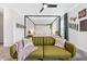 Main bedroom with a four-poster bed, green couch, and animal print decor at 2763 Oxymoron Way, Kissimmee, FL 34746