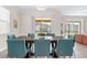 Bright dining room with large table and teal chairs, view of backyard at 2763 Oxymoron Way, Kissimmee, FL 34746