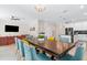 Open dining area with large table and teal chairs, view of living area at 2763 Oxymoron Way, Kissimmee, FL 34746