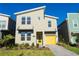 Modern two-story home with yellow garage door and landscaped front yard at 2763 Oxymoron Way, Kissimmee, FL 34746