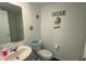 Small bathroom with toilet, sink, and beach-themed decor at 3203 Laurent Loop, Davenport, FL 33837
