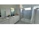 Modern bathroom with double vanity, large shower, and gray tile at 3203 Laurent Loop, Davenport, FL 33837