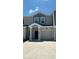 Two-story townhome with gray siding, two-car garage, and a small front yard at 3207 Laurent Loop, Davenport, FL 33837