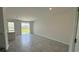 Spacious living room with gray tile floors and sliding glass doors to patio at 3207 Laurent Loop, Davenport, FL 33837