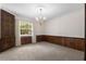 Spacious dining room with neutral carpet, wood paneling, and a chandelier at 3651 S Rosalind Ave, Orlando, FL 32806