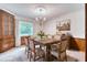 Staged dining room with farmhouse style table, seating for six, and a decorative chandelier at 3651 S Rosalind Ave, Orlando, FL 32806