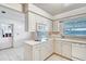 Bright kitchen features white cabinets, modern appliances, and a window overlooking the water at 3651 S Rosalind Ave, Orlando, FL 32806