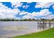 Scenic view of lake featuring a wooden dock, lush greenery, and blue skies at 3651 S Rosalind Ave, Orlando, FL 32806
