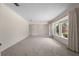 Open living room with neutral carpet and bright natural light from the large windows at 3651 S Rosalind Ave, Orlando, FL 32806