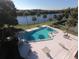 Community pool with lounge chairs and lake view at 610 Cranes Way # 307, Altamonte Springs, FL 32701