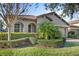Well-maintained house with lush landscaping, arched entryway, and a terracotta tile roof at 10713 Berry Creek Rd, Orlando, FL 32836