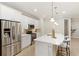 Bright kitchen with white cabinets, stainless steel appliances, and a large island with pendant lighting at 10713 Berry Creek Rd, Orlando, FL 32836