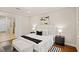 Comfortable main bedroom with hardwood floors, a white upholstered bed, and an ensuite bathroom at 10713 Berry Creek Rd, Orlando, FL 32836