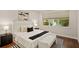 Comfortable main bedroom with hardwood floors, a white upholstered bed, and large windows at 10713 Berry Creek Rd, Orlando, FL 32836