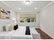 Spacious main bedroom with hardwood floors, a white upholstered bed, and large windows at 10713 Berry Creek Rd, Orlando, FL 32836