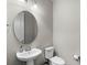 Small, updated half bathroom with a pedestal sink and an oval mirror at 10713 Berry Creek Rd, Orlando, FL 32836