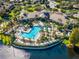 Aerial view of community pool and lake, surrounded by lush landscaping at 1348 Gilford Point Ln, Davenport, FL 33896