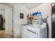 Bright laundry room featuring washer, dryer, shelving, and white walls at 2021 Sunderland Rd, Maitland, FL 32751