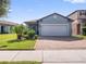 One-story home with gray exterior, two-car garage, and landscaped front yard at 3570 Southern Cross Loop, Kissimmee, FL 34744