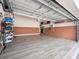 Two-car garage with light wood flooring and storage at 3570 Southern Cross Loop, Kissimmee, FL 34744
