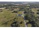 An aerial view of a home on a tree-lined street surrounded by lush greenery at 3705 Ridge Run Dr, Minneola, FL 34715
