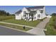 A well-manicured lawn leads to this two-story modern home with black accents, stone walkway, and a driveway at 3705 Ridge Run Dr, Minneola, FL 34715